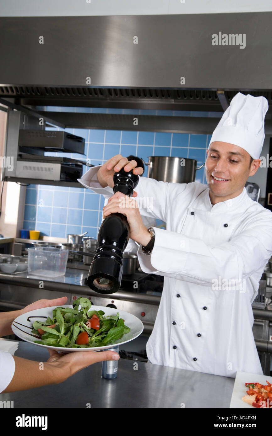 Un chef sazonar una ensalada Foto de stock