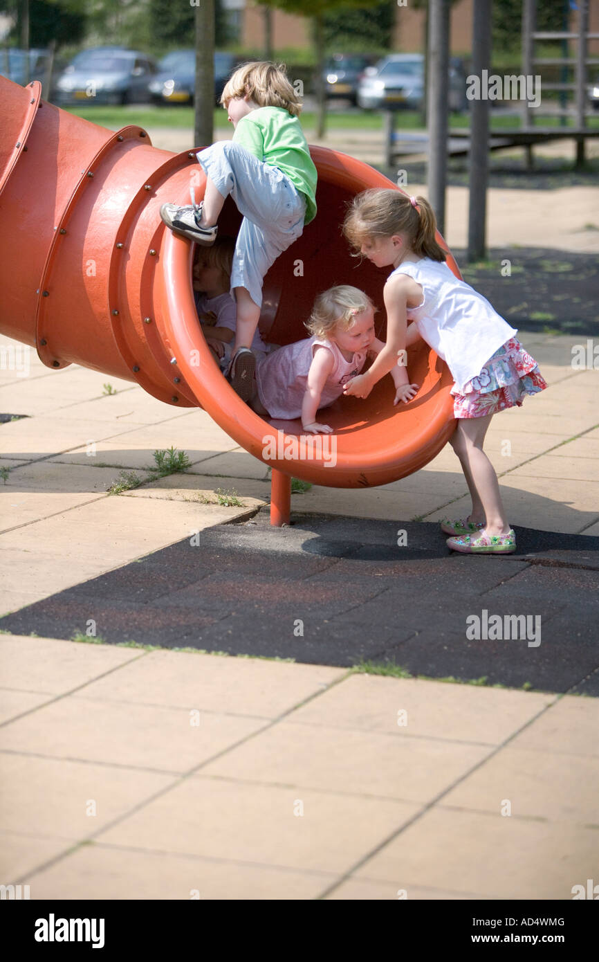 Los niños subirse a un tubo de hierro en el patio Foto de stock