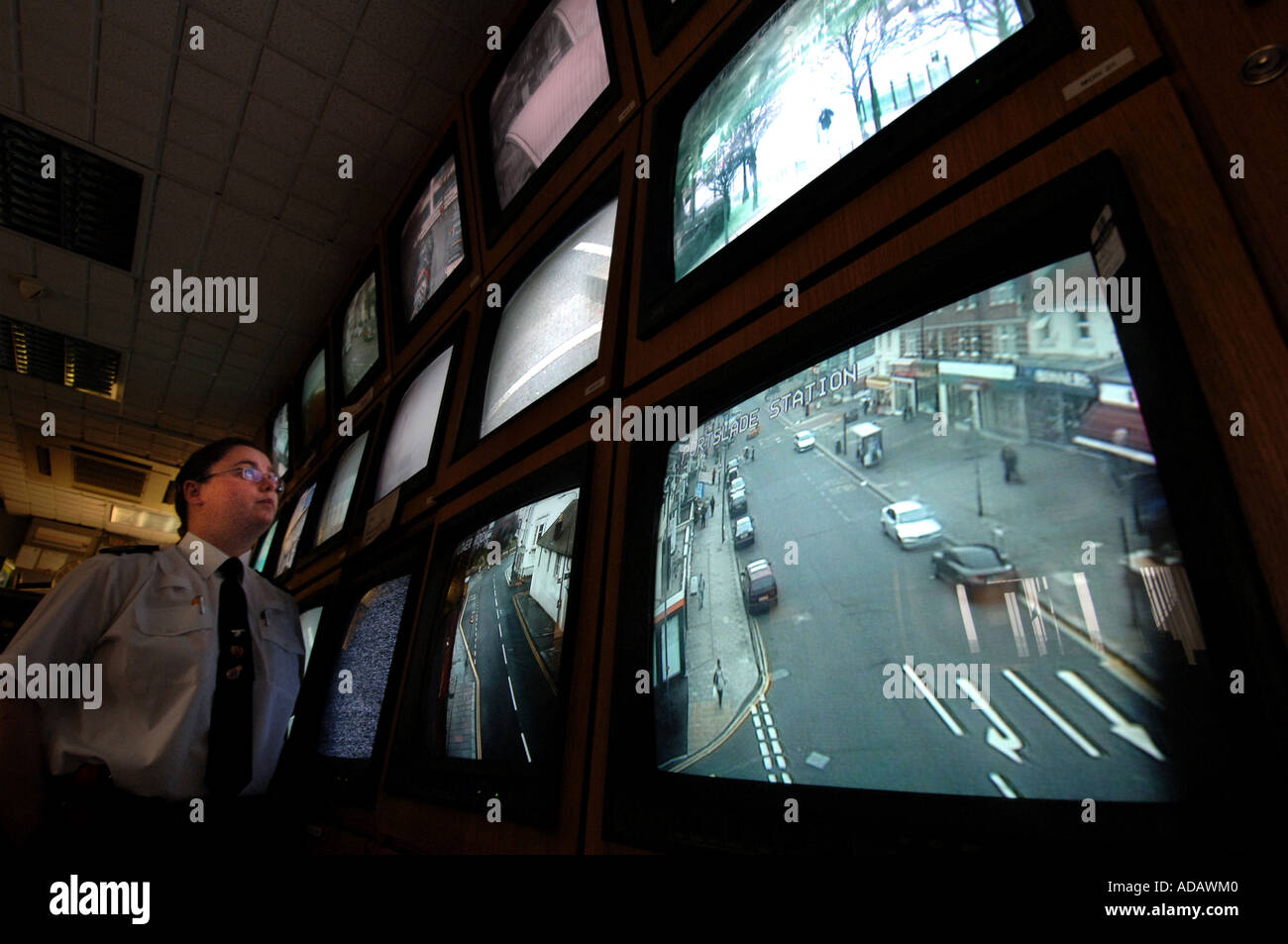 Un operador de CCTV en Brighton comisaría controla un banco de pantallas de cámaras de vigilancia en las calles de la ciudad Foto de stock