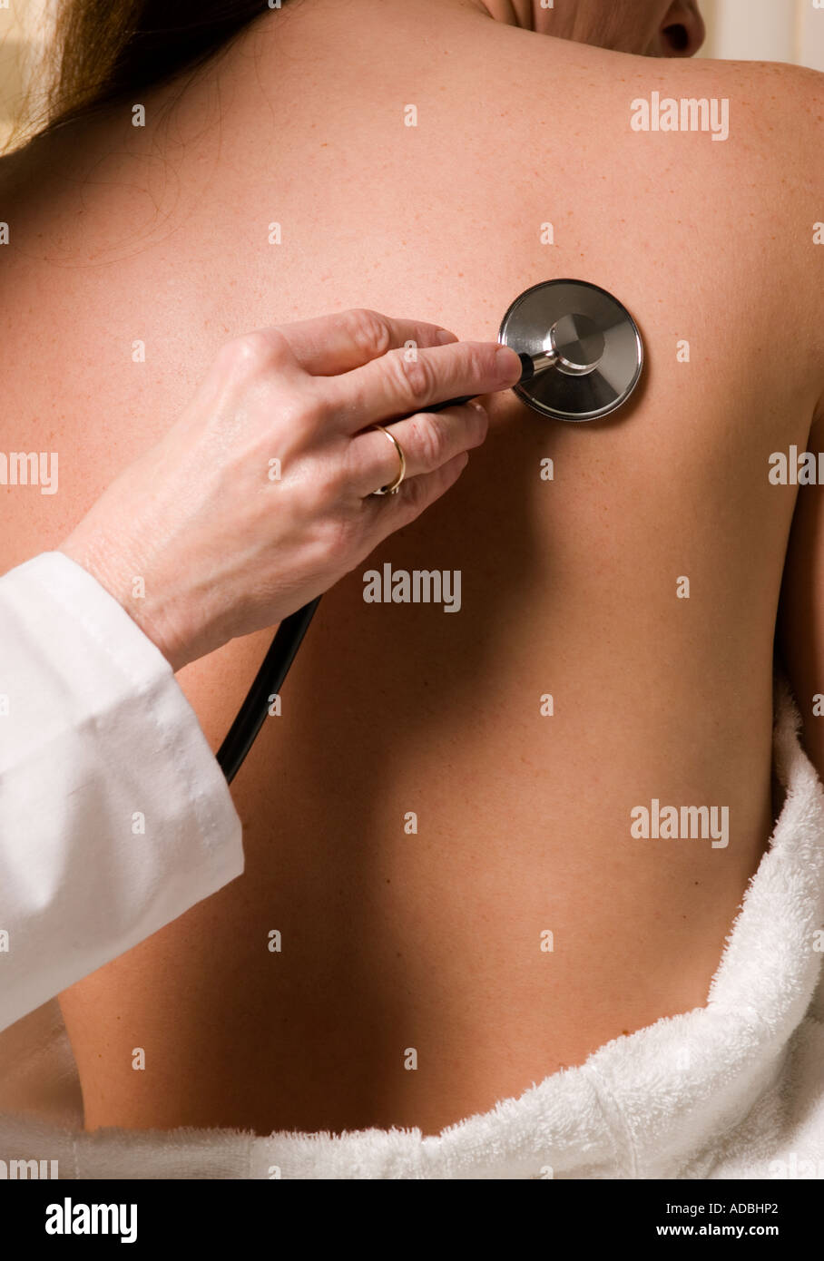 Mujer desnuda Doctor examina paciente femenino con Stethescope celebrada para volver Fotografía de stock