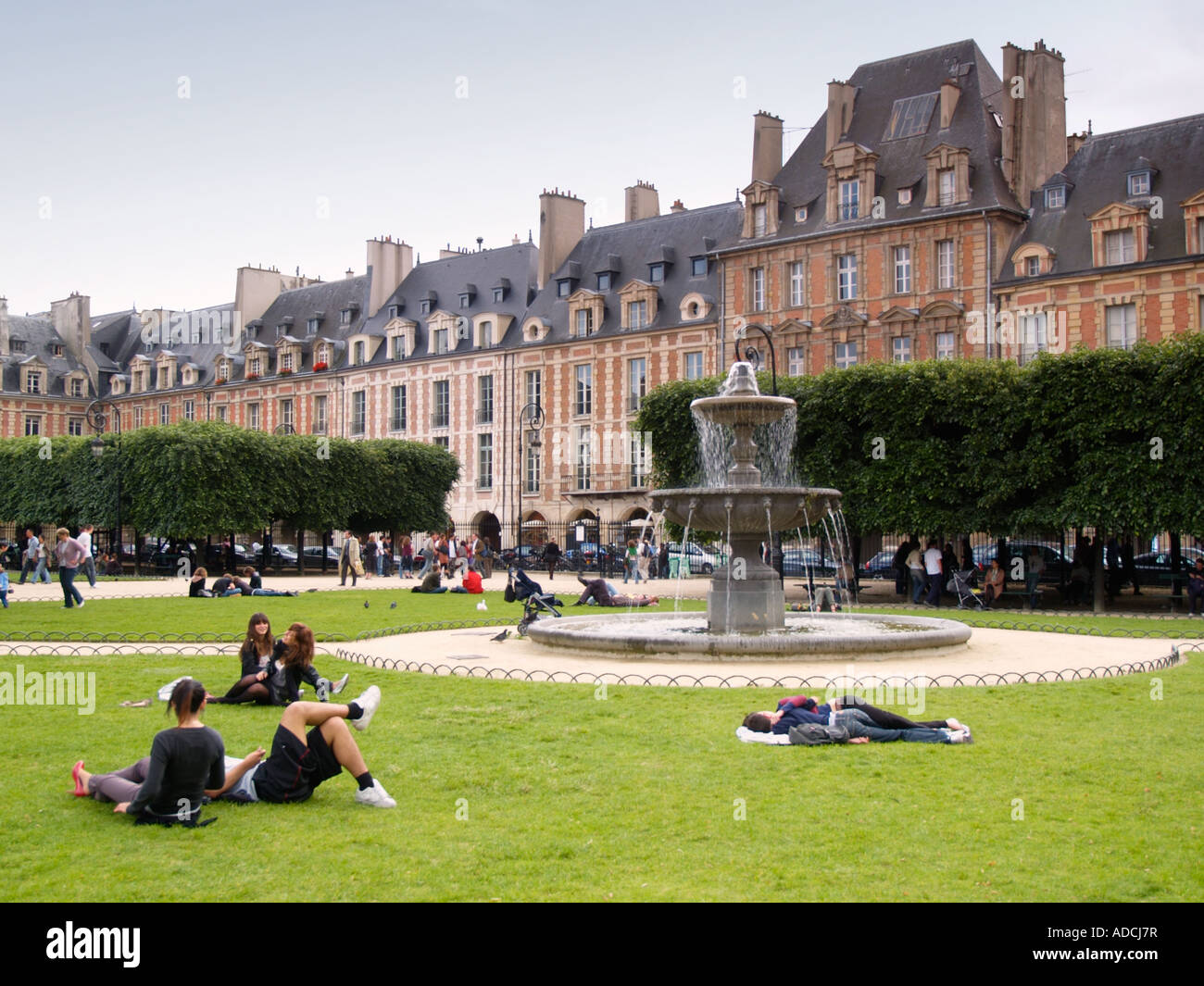 La gente descansando en el parque de la place des Vosges, Le Marais, París Francia Foto de stock