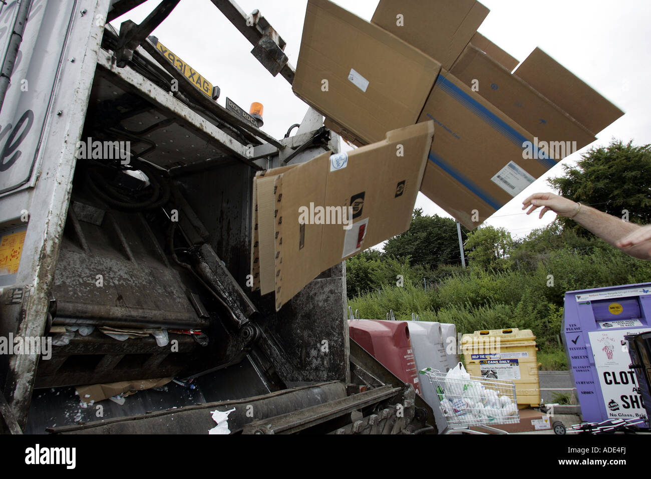 Cajas de cartón ser arrojado a la parte trasera del camión de basura. Foto de stock