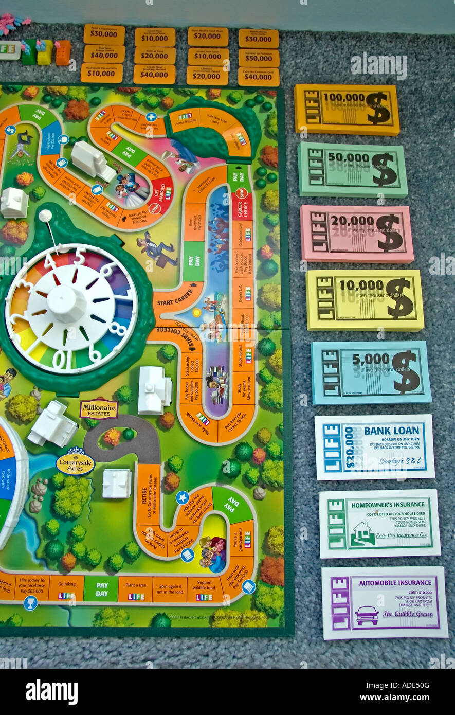 El juego de la vida" por Milton Bradley. El tablero de juego y todas sus  piezas, como el dinero y tarjetas, están todas dispersas Fotografía de  stock - Alamy