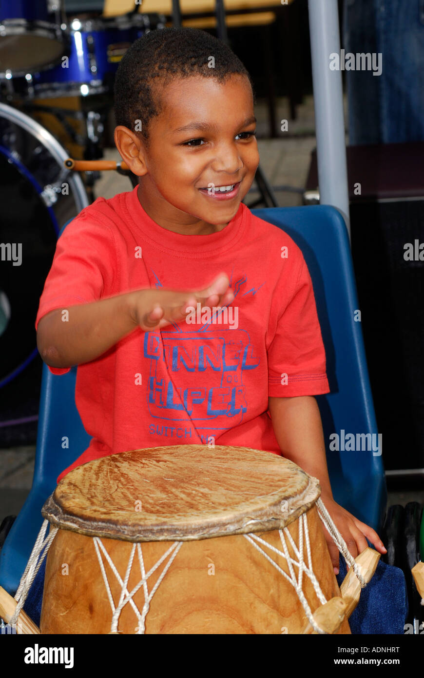 Niño de 4 años tocando los tambores en un día de diversión Nueva Malden Surrey UK Foto de stock