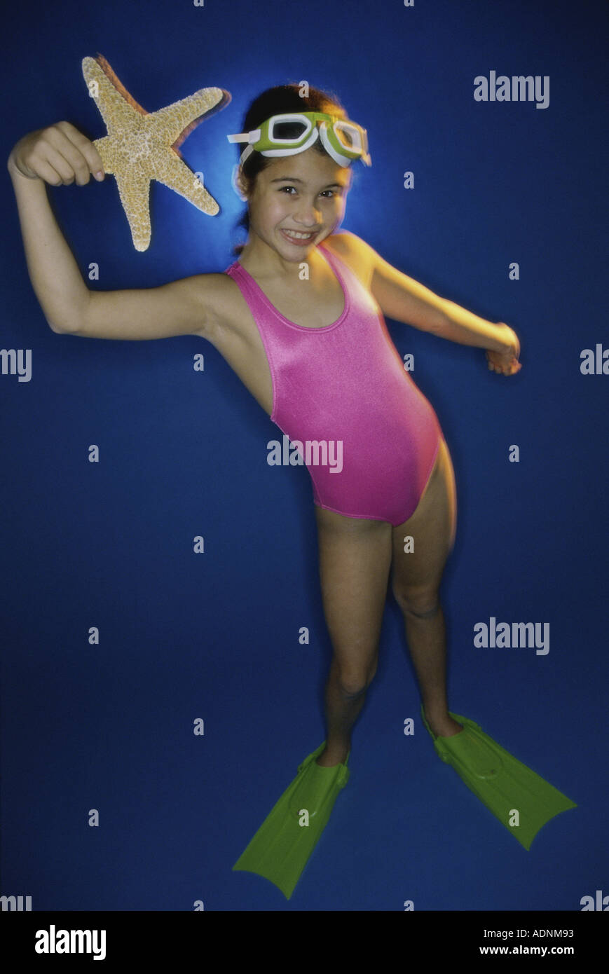 Retrato de una niña en traje de baño sosteniendo una estrella de mar  Fotografía de stock - Alamy