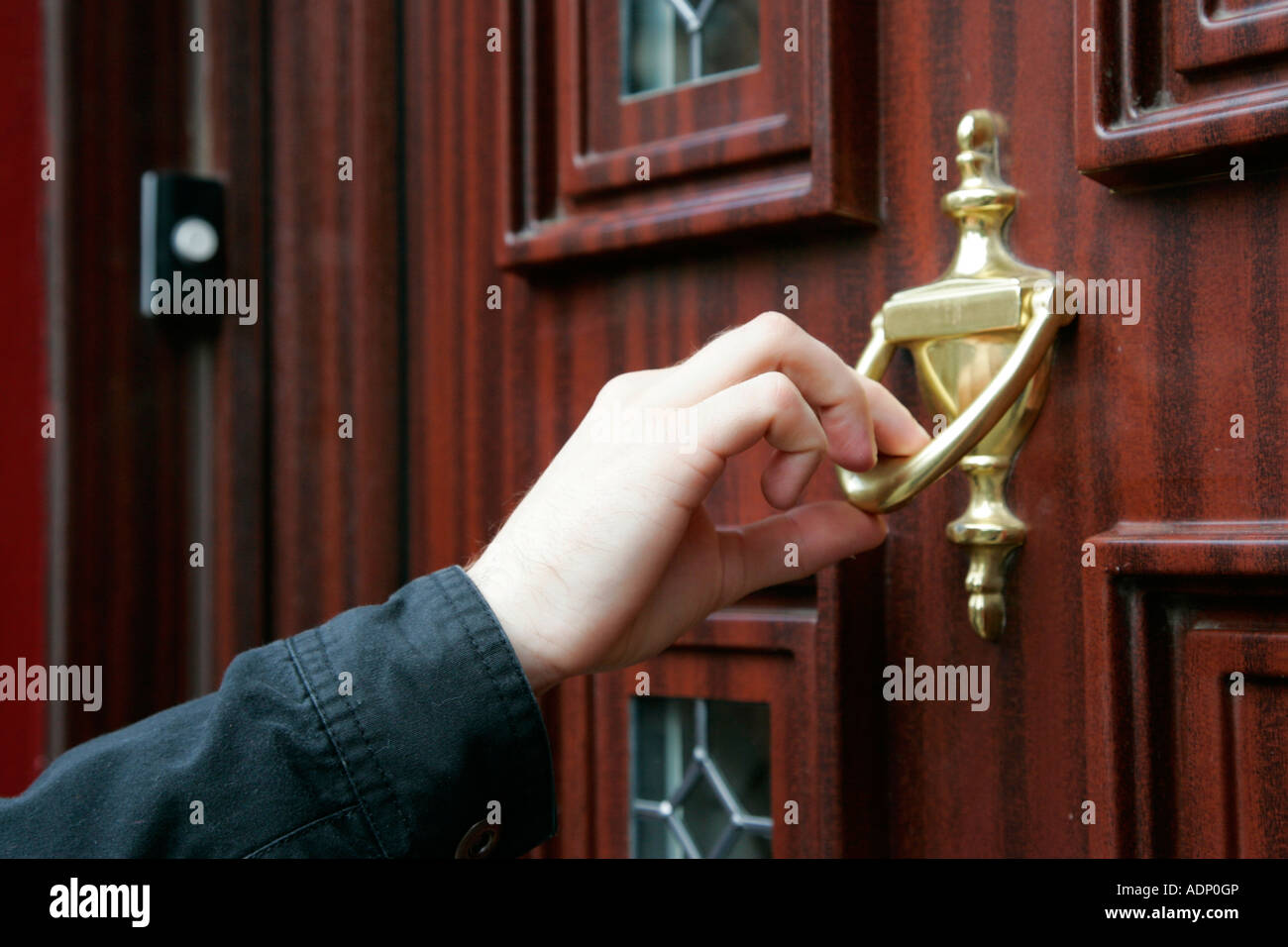 Mans mano usando la puerta de madera del eyector de upvc efecto puerta en  lugar del timbre de llamada en frío hogar Fotografía de stock - Alamy