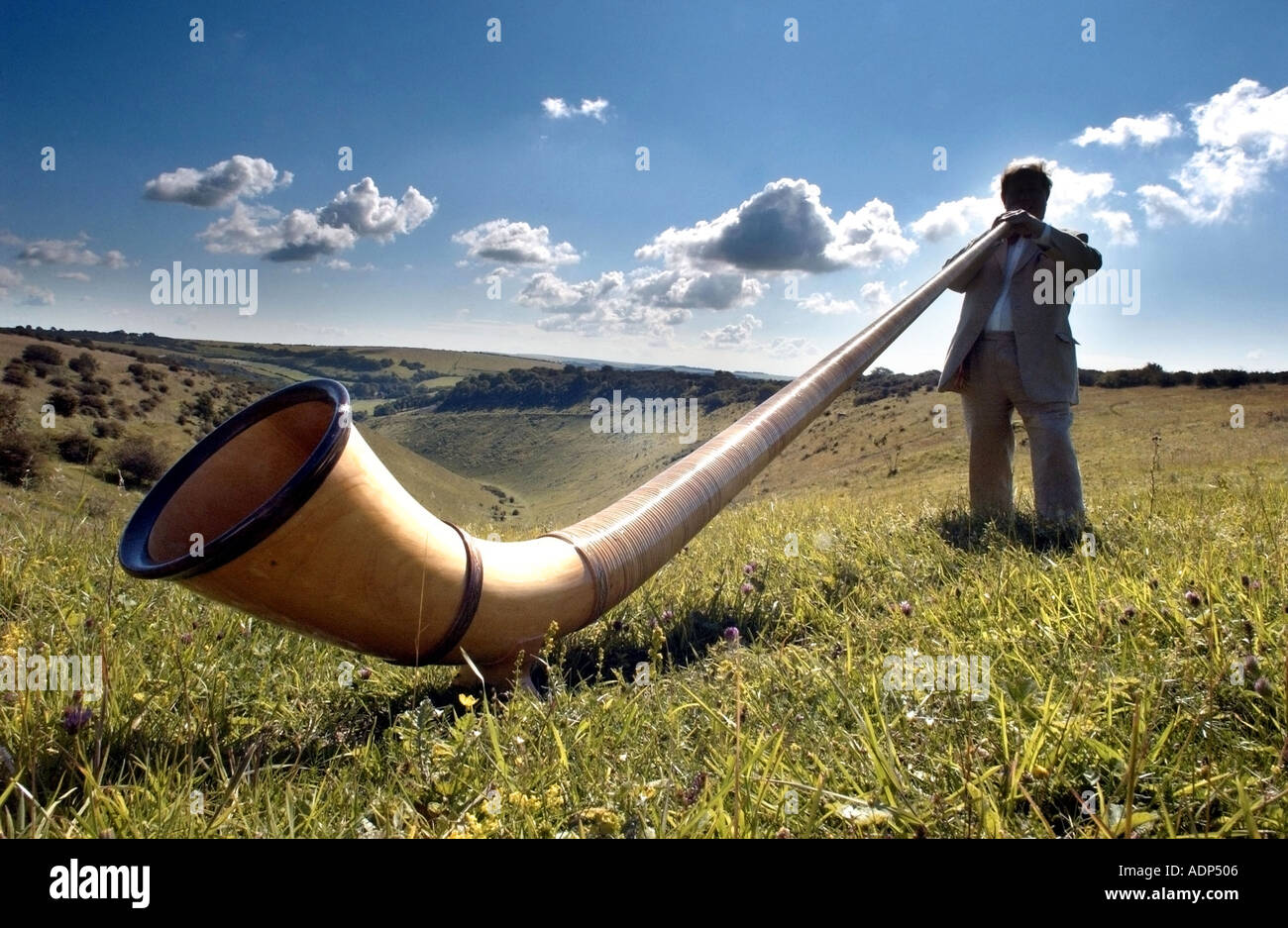 El hombre desempeña un Alpenhorn alphorn suizo o el extraño instrumento  musical Fotografía de stock - Alamy