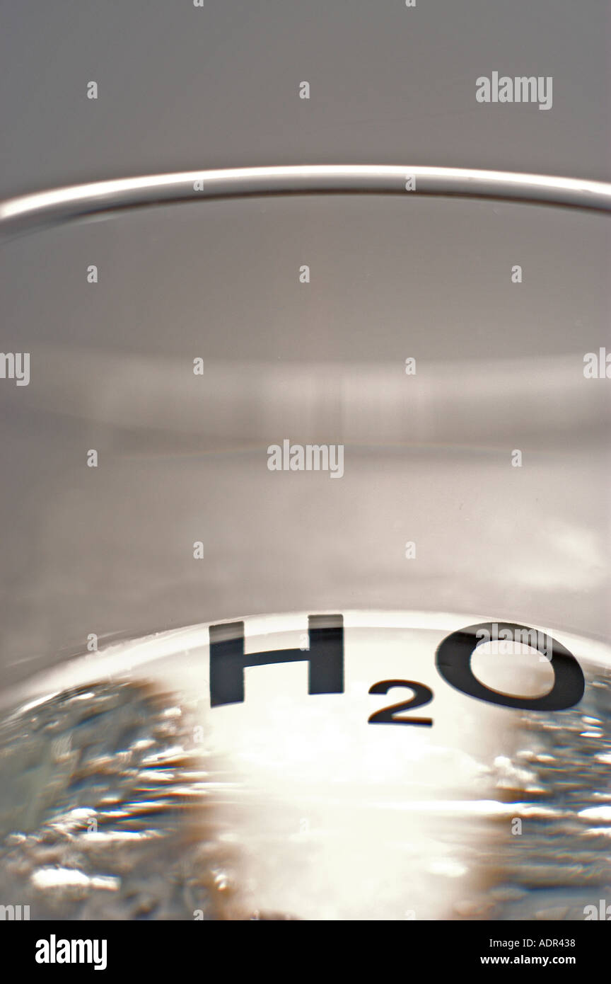Una foto de un vaso de agua con H2O DISEÑO. Foto de stock