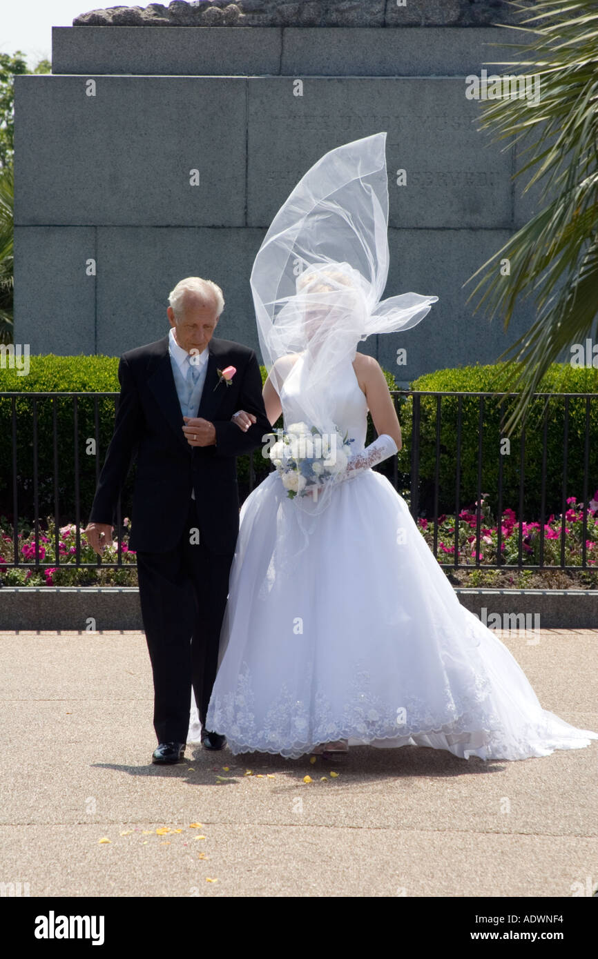 Una novia y su falther camina por el pasillo en una boda al aire libre el  velo de la novia es volar sobre su cabeza Fotografía de stock - Alamy
