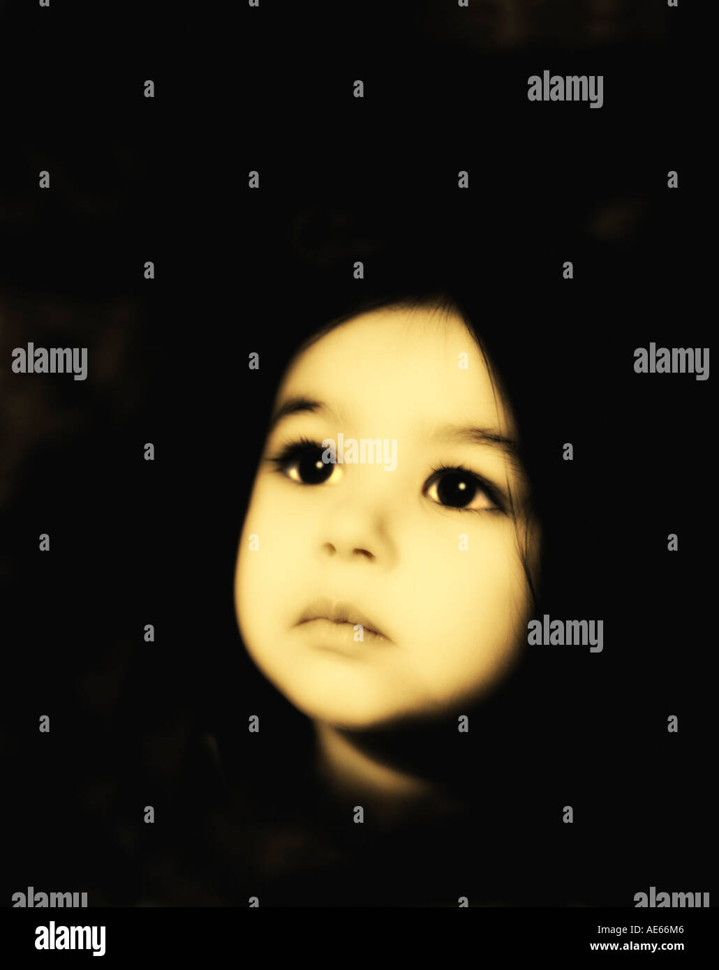 Hermoso solitario enigmática niña de dos años busca con ojos grandes en la esperanza. En tonos sepia. Foto de stock
