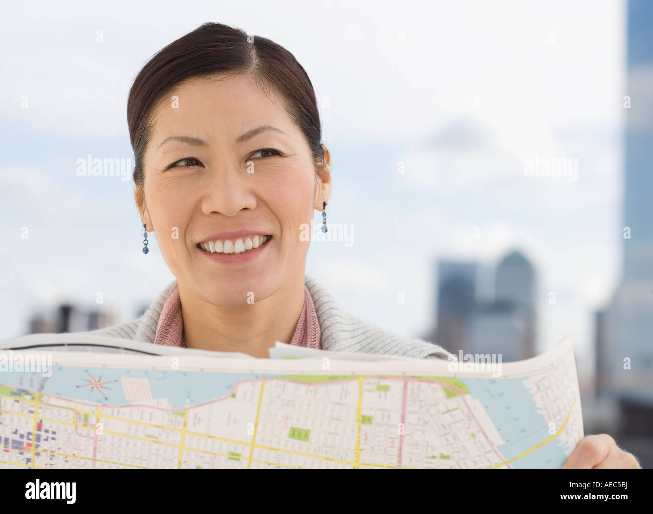Mujer Asiática de mediana edad celebración mapa Foto de stock