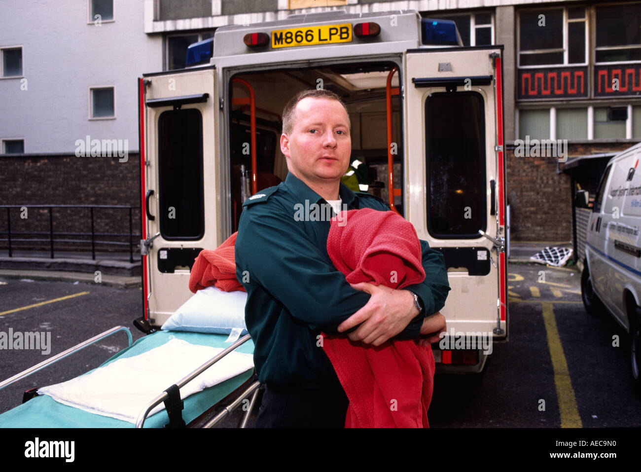 Retrato de un miembro de la tripulación de Ambulancias de Londres con una manta detrás de su ambulancia de emergencia Foto de stock