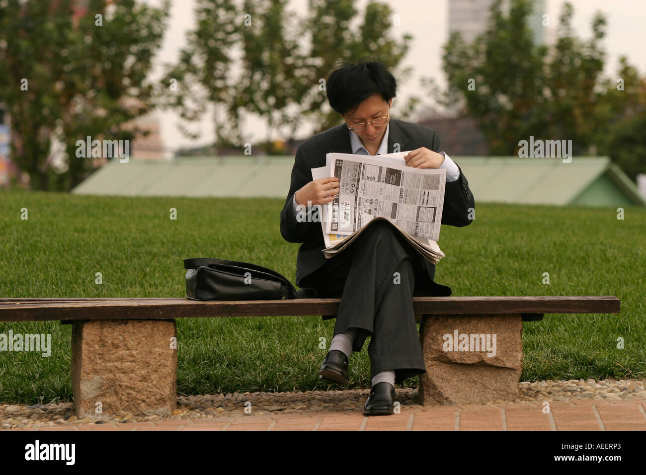 Shanghai China oficinista leyendo anuncios de trabajo antes de pasar a trabajar en la oficina del distrito de la nueva zona de Pudong Foto de stock
