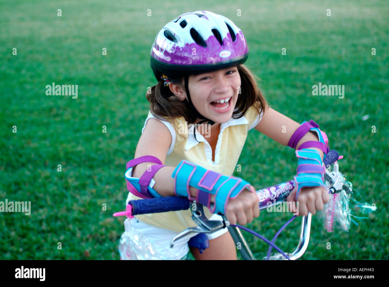 Ni a montando bicicleta vistiendo ropa protectora Fotograf a de