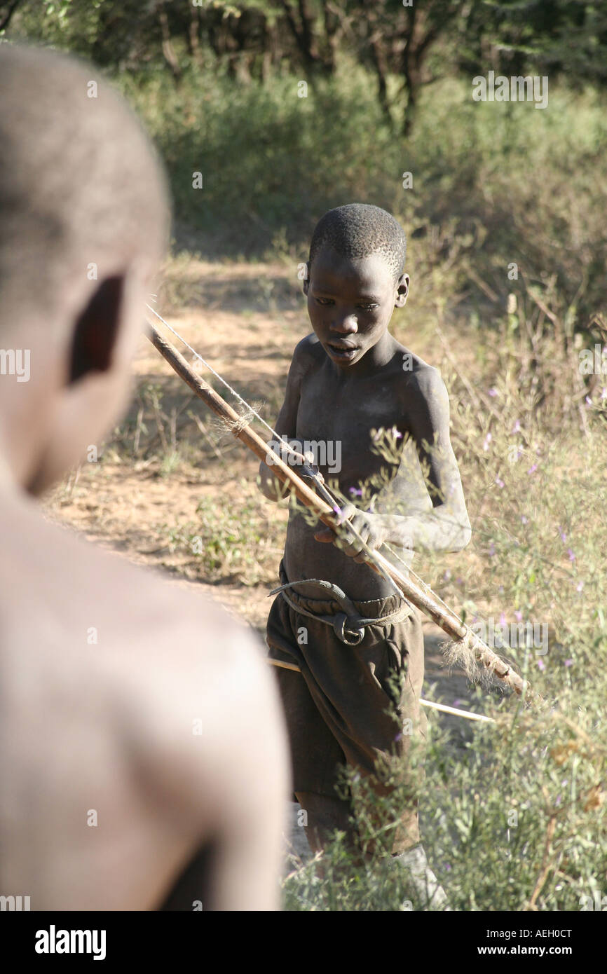 Cazador joven muchacho de cazadores recolectores de la tribu Hadza aves de caza con arco y flecha, cerca del lago Eyasi en Tanzania, África Oriental Foto de stock