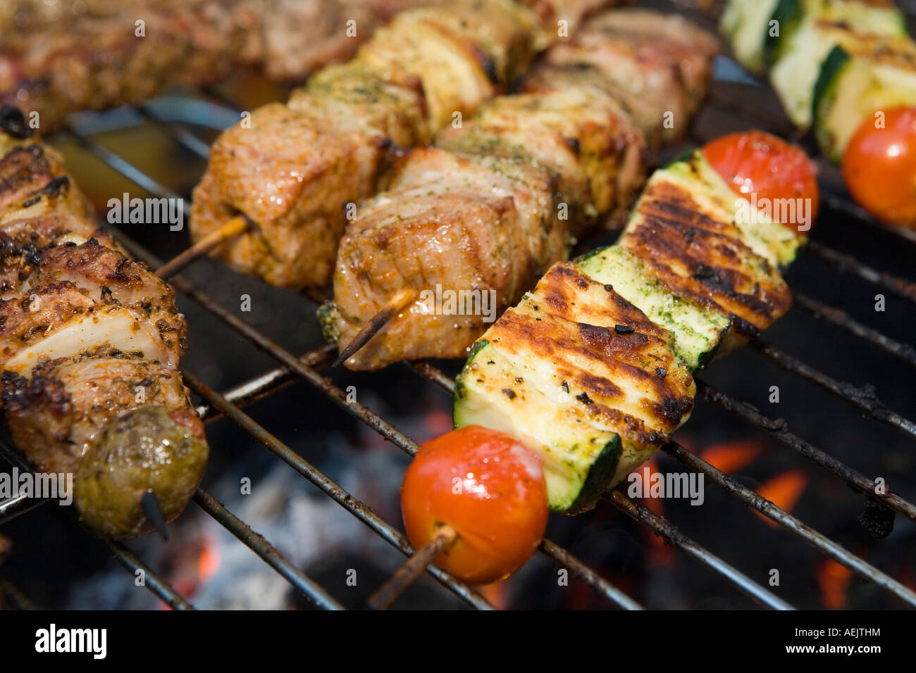 El asado de carne y verduras escupe sobre una parrilla Foto de stock