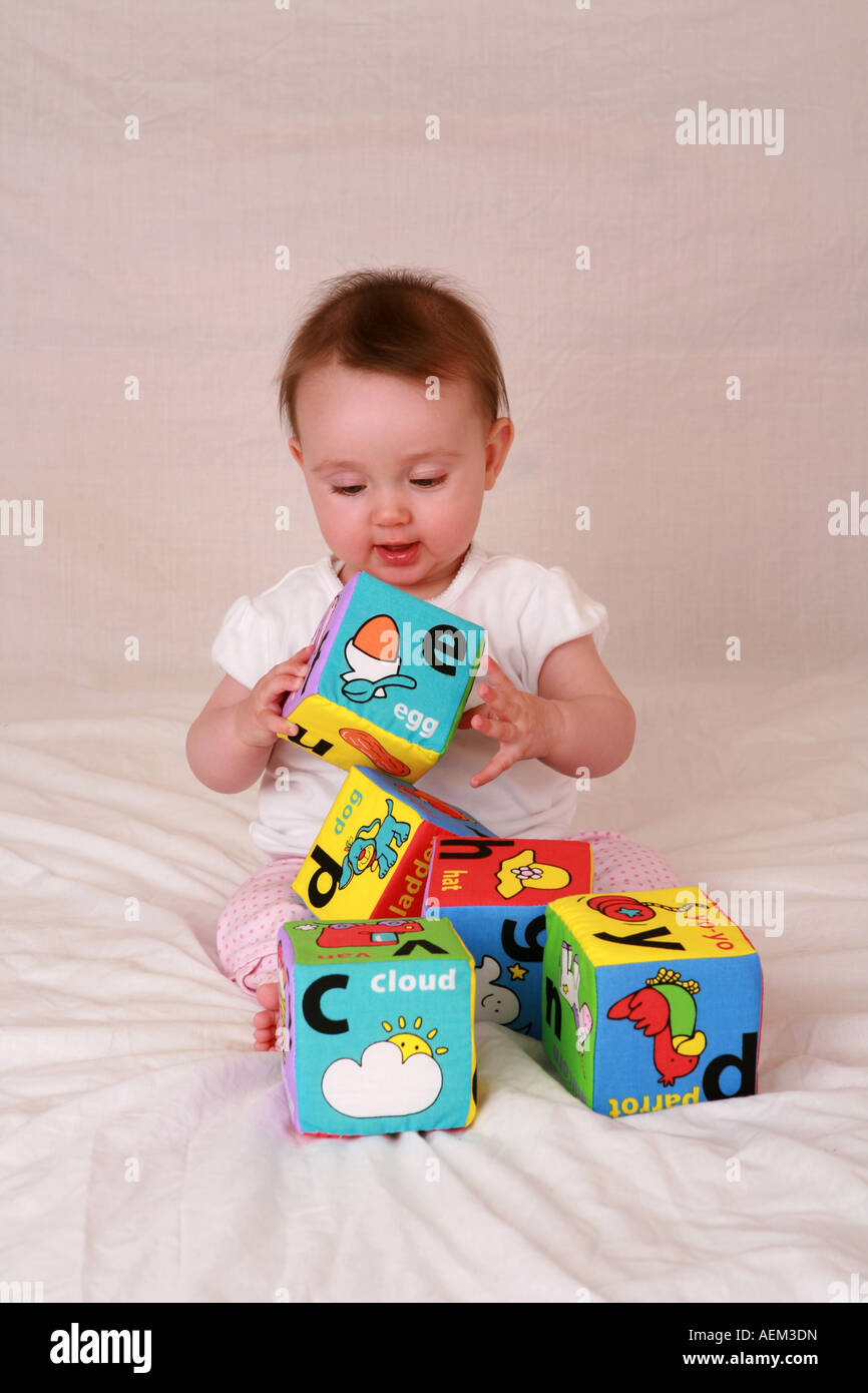 Inocente Angelical Bebe Recien Nacido A 7 Meses De Edad Sentado Jugando Con Colores Suaves Juguetes De Ladrillo Del Alfabeto Alegre Y Contento Fotografia De Stock Alamy