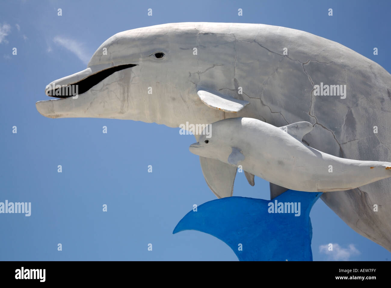 La escultura de la madre y el bebé delfín contra un cielo sin nubes. Foto de stock
