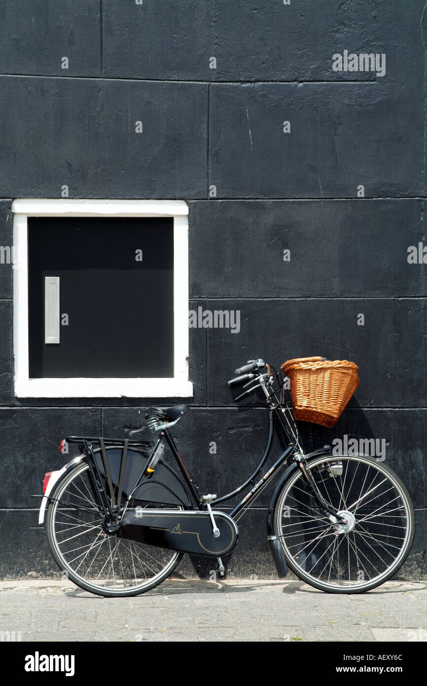 Old Dutch bicycle se inclina sobre la pared negra en Maassluis, cerca de la ciudad de Rótterdam, Holanda Europa UE Foto de stock