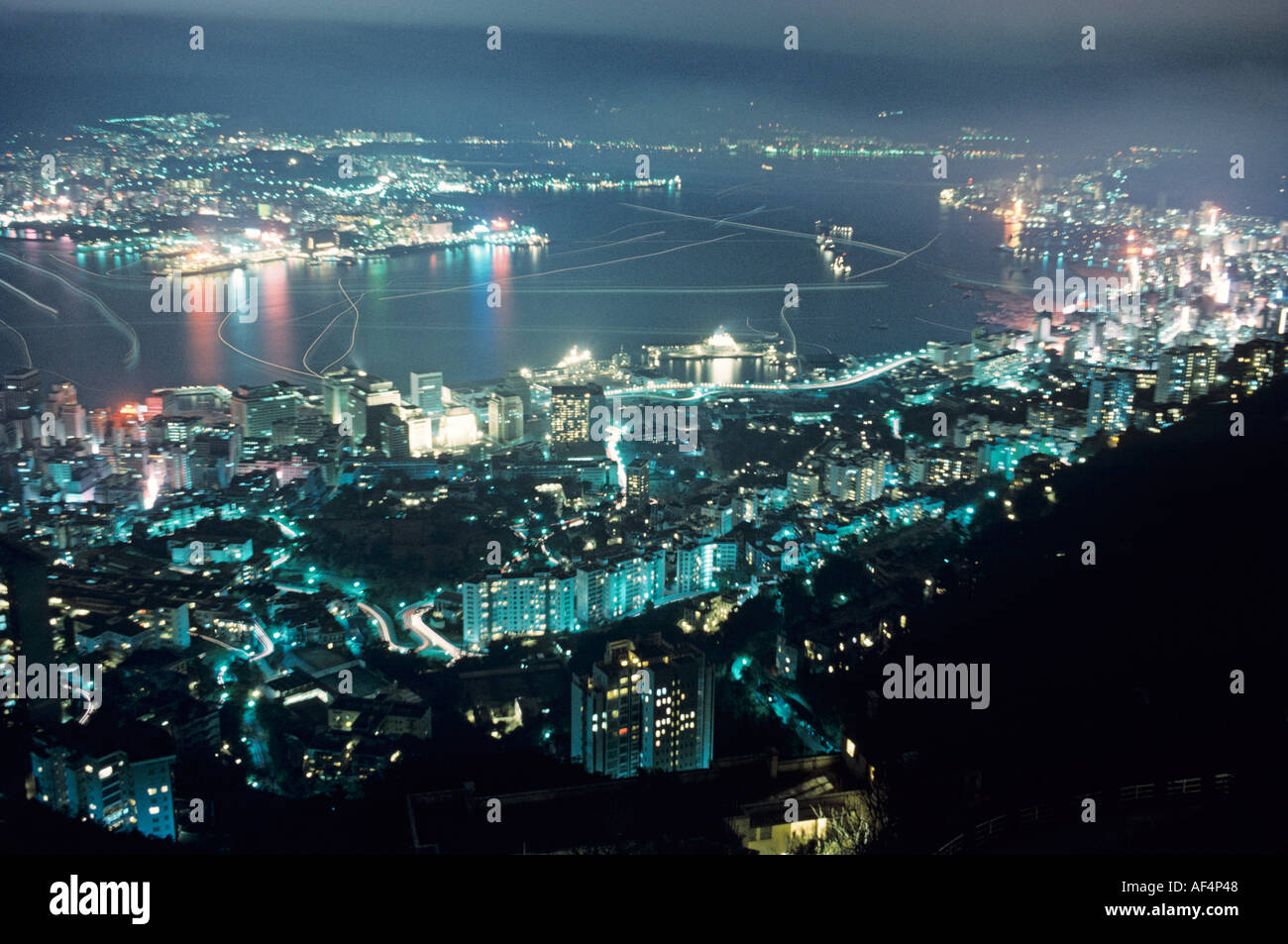 Vista desde Victoria Peak nocturno en 1967 con algunos grandes edificios altos sobre el puerto Victoria y Kowloon Hong Kong Foto de stock