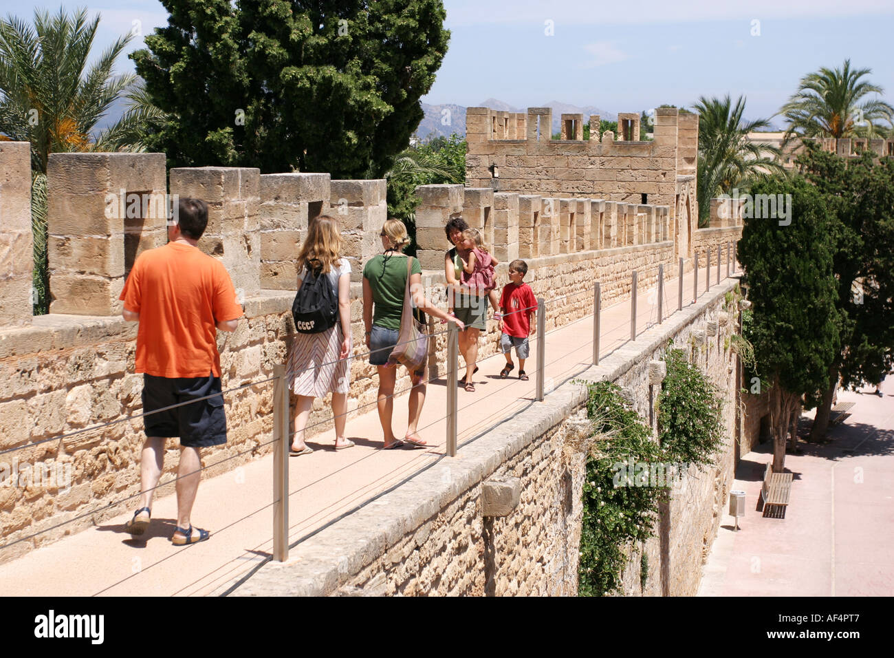 Los turistas que caminan por la gran muralla que rodea el casco antiguo de la ciudad de Alcudia, Mallorca, España Foto de stock