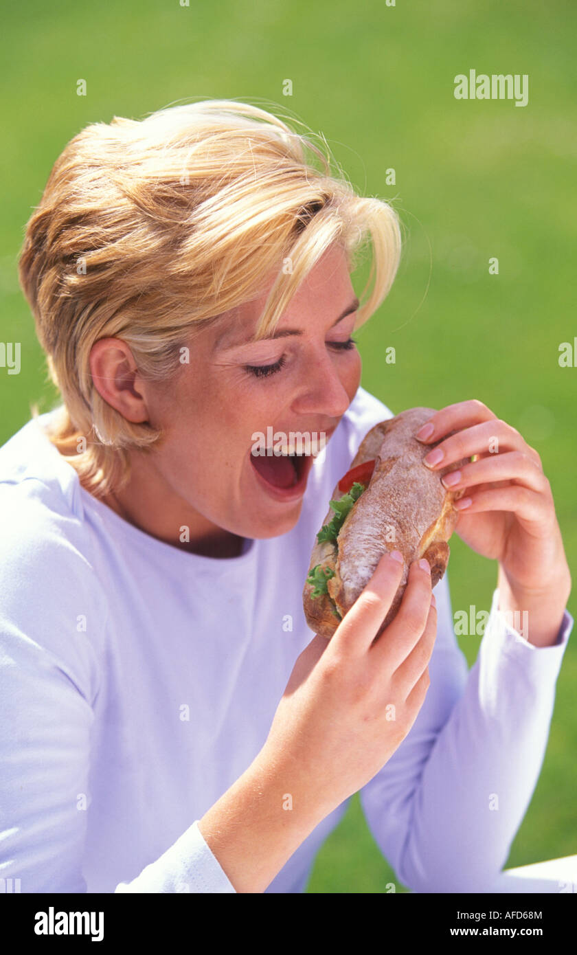 Mujer rubia de comer un bocadillo saludable Foto de stock