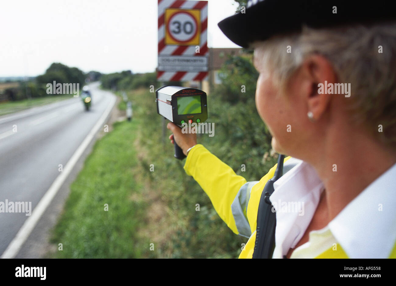 Una mujer policía raodside con una mano sosteniendo la cámara de velocidad en el REINO UNIDO Foto de stock