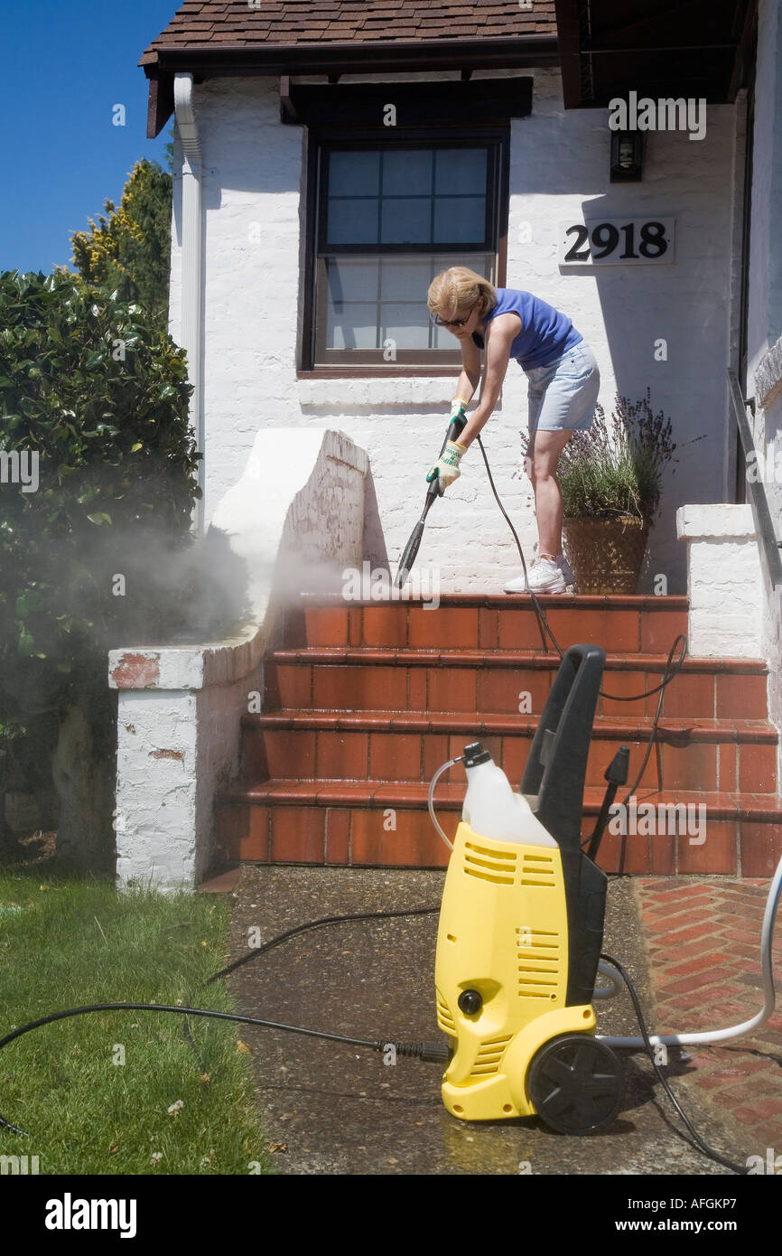 Mujer con arandela de presión para limpiar el porche de su casa, Seattle,  Washington, EE.UU Fotografía de stock - Alamy