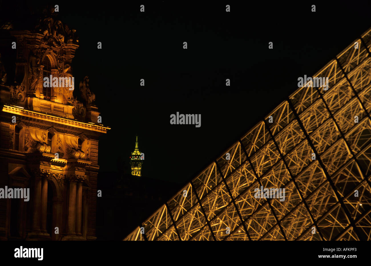 La Pirámide del Louvre iluminado en la noche, con la punta de la Torre La Pirámide del Louvre iluminado en la noche, con la punta de la Torre