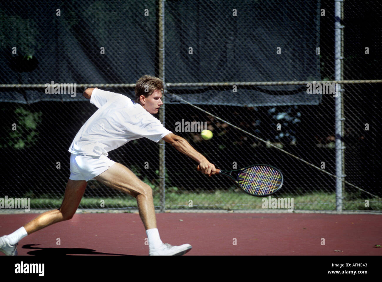 Macho adulto joven juega en el torneo de tenis Foto de stock