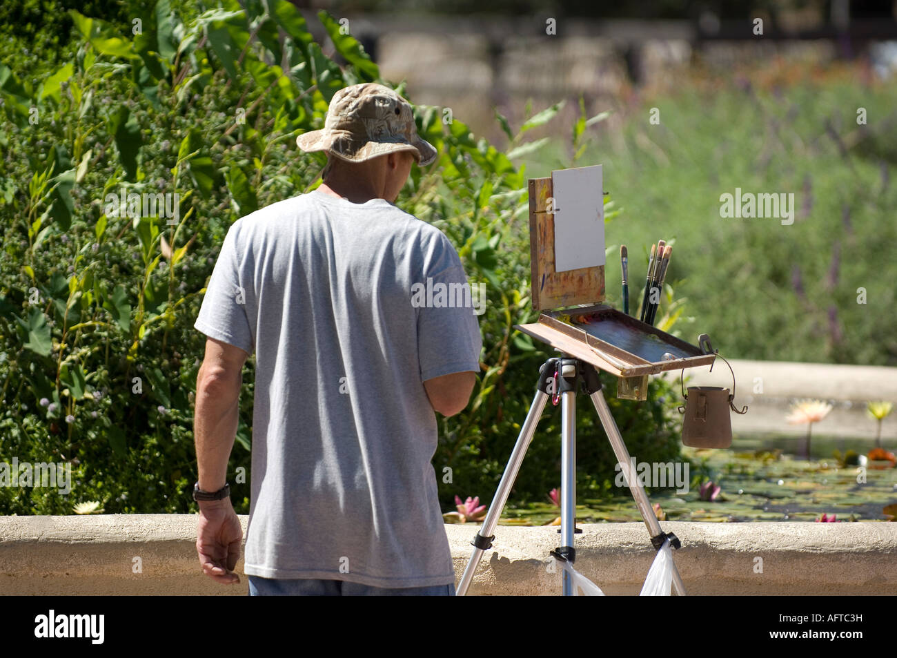 Un pintor analiza su escena cuidadosamente como él comienza su obra Foto de stock