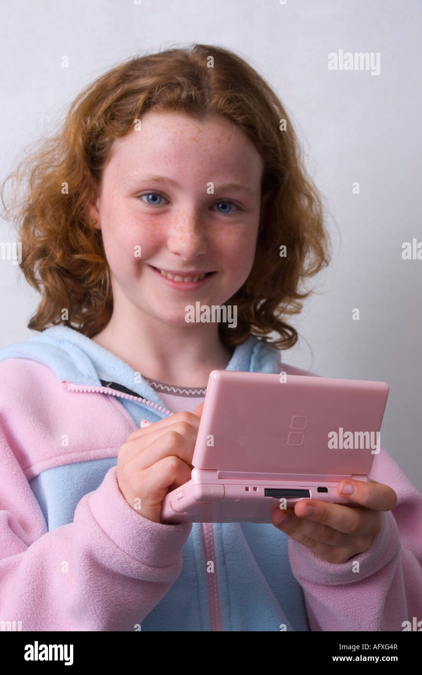 Una niña de 11 años jugando en una máquina de juego de Nintendo DS Lite  utilizando un lápiz Fotografía de stock - Alamy