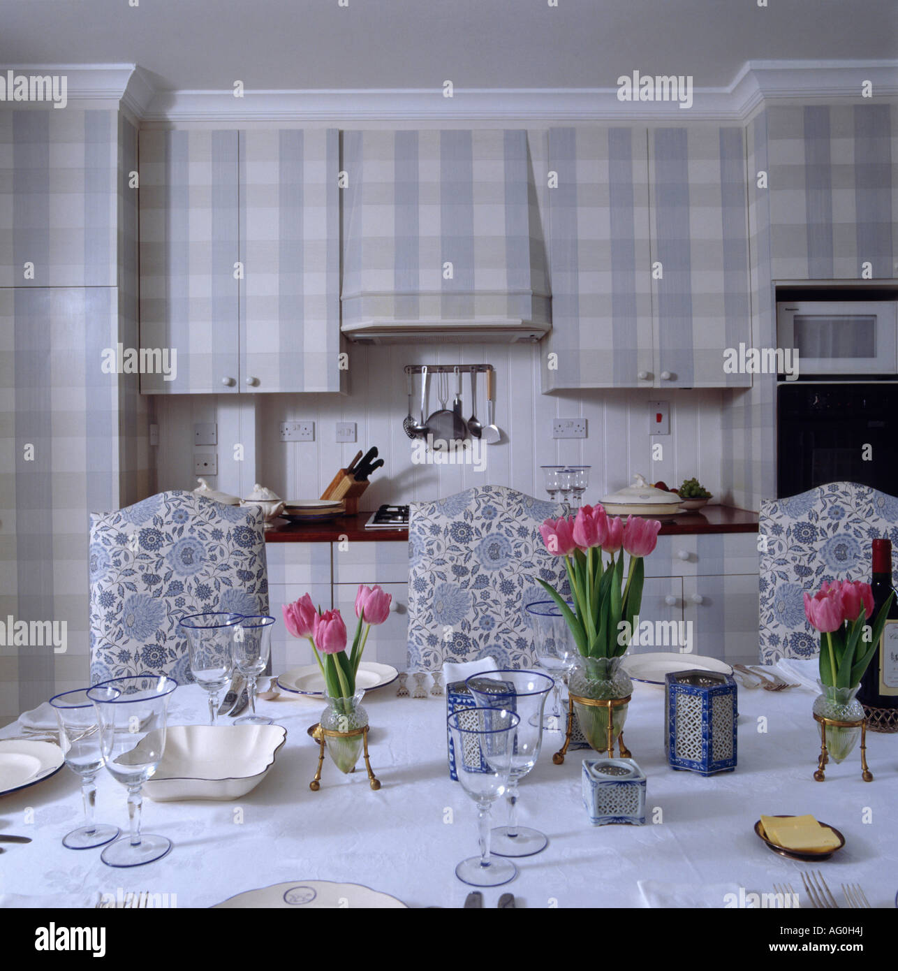 Rosa tulipanes en la mesa de comedor en la cocina con sillas ... Rosa tulipanes en la mesa de comedor en la cocina con sillas ...