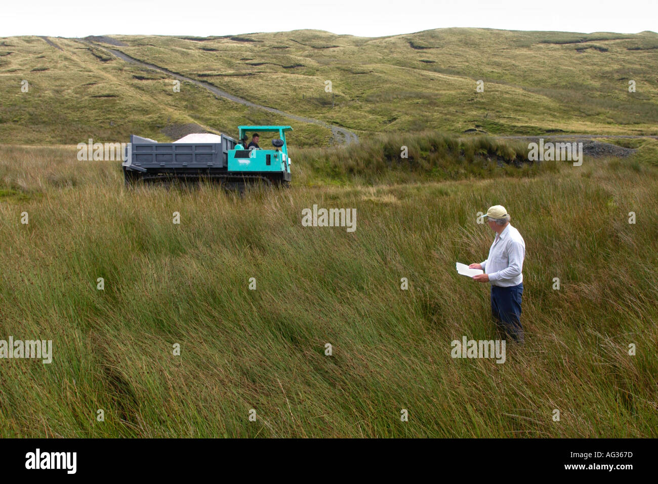 El Dr. Stephen Marsh Smith levantamientos topográficos para esparcir cal cerca de la cumbre de Plynlimon cerca Eisteddfa Gurig, Ceredigion, Mid-Wales Foto de stock