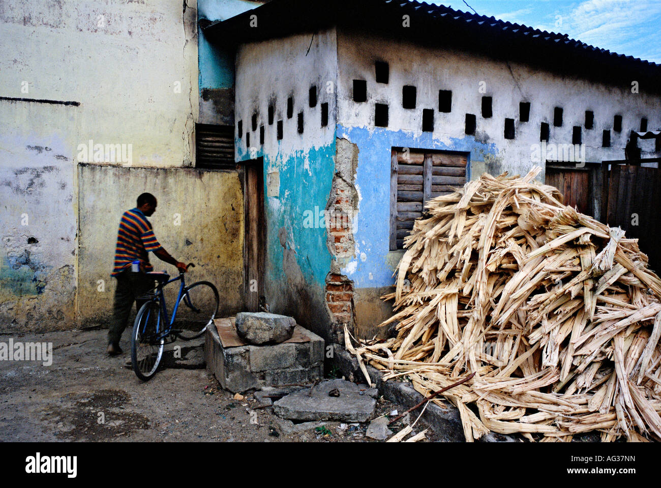 Hombre con bicicleta entra en un edificio en Baracoa, Cuba Foto de stock