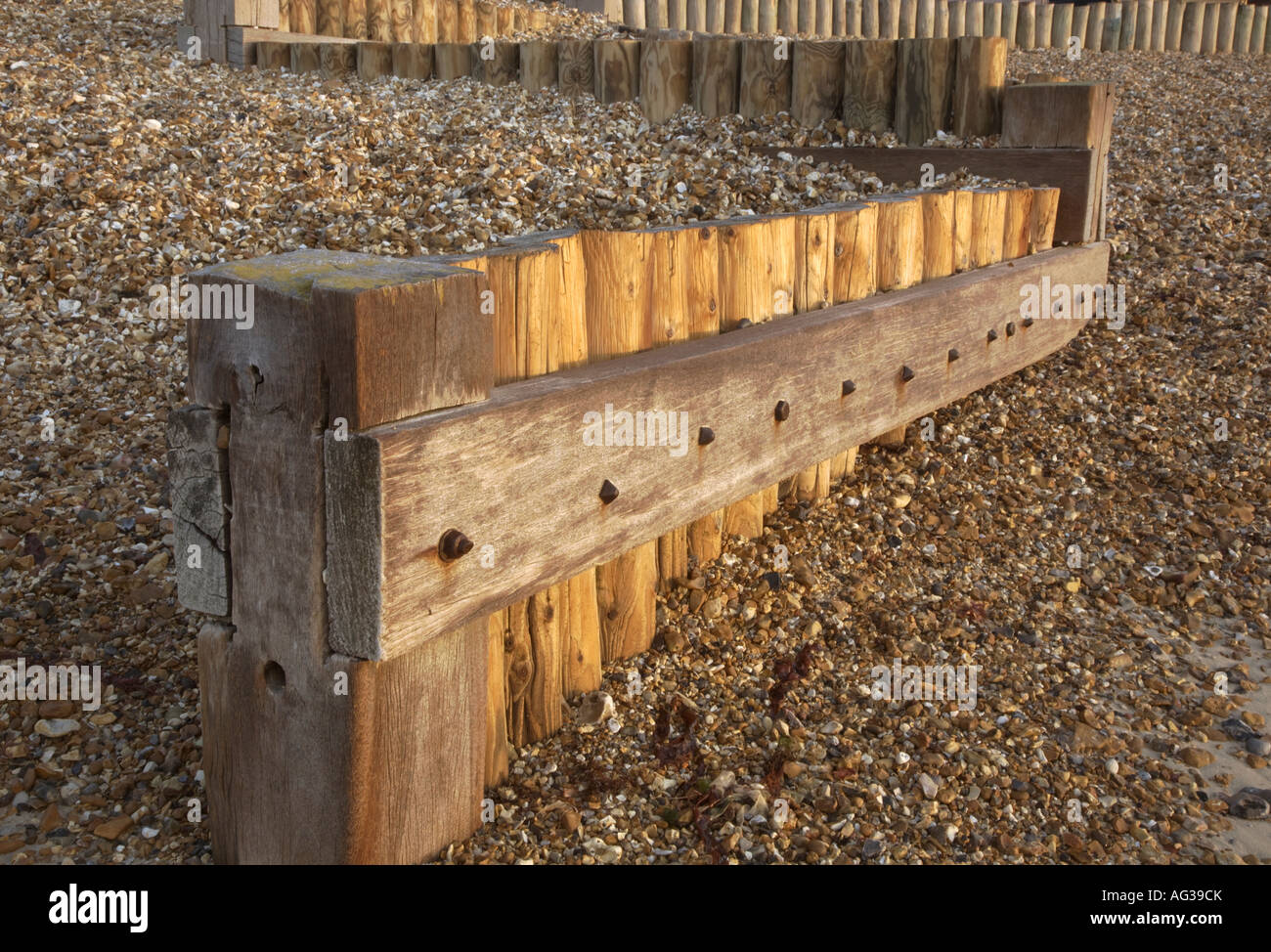 Groynes madera para defensa del mar en la playa de guijarros en Calshot en Hampshire Foto de stock