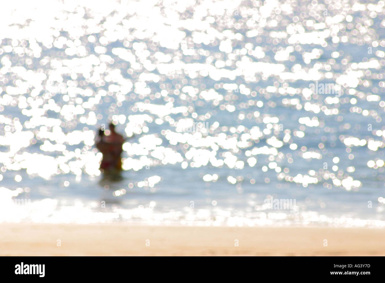 Pareja en el mar mar siluetas contra reflejos borrosos soft focus Foto de stock