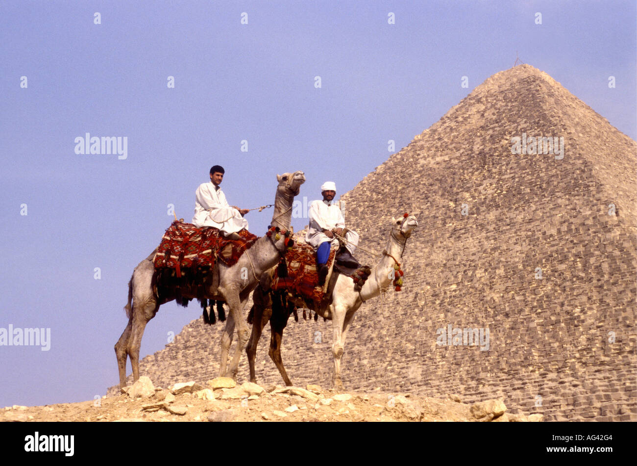Dos jinetes de camellos suponen cerca de la pirámide de Keops en Giza Egipto Foto de stock
