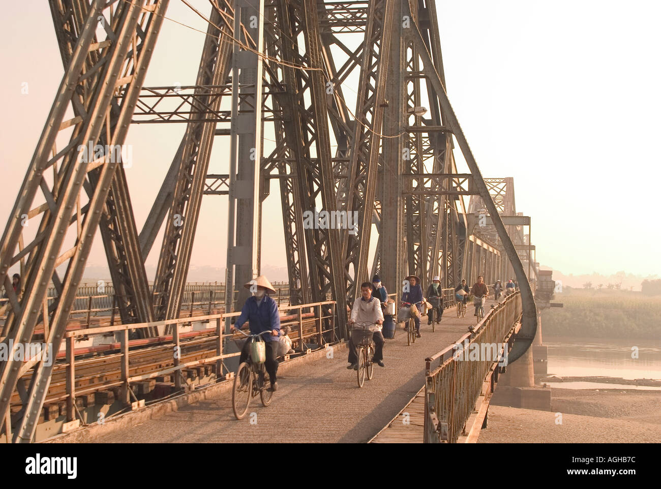 Los ciclistas cruzar el Puente Largo Bien al amanecer, Hanoi, Vietnam Foto de stock