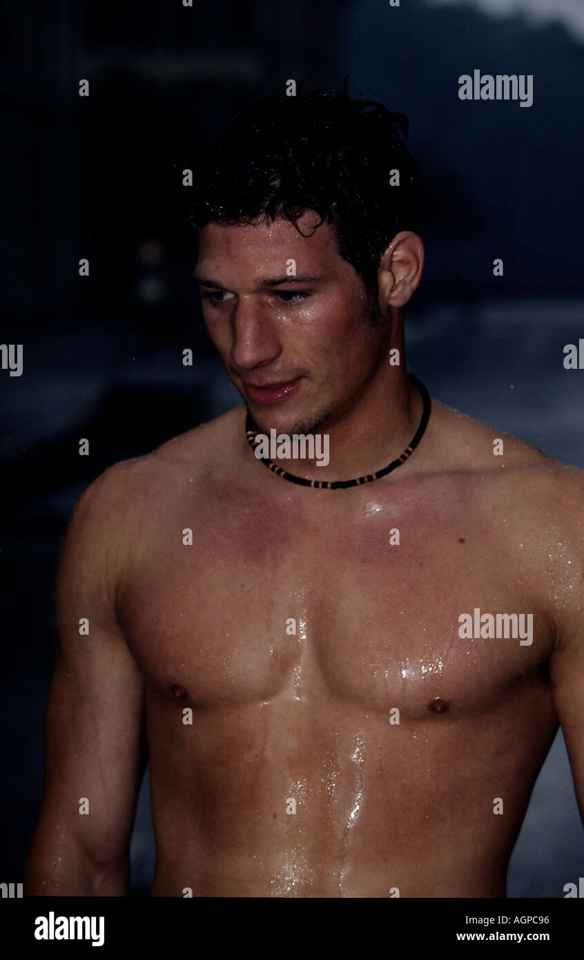 Joven sin camisa caminar bajo la lluvia Fotografía de stock - Alamy