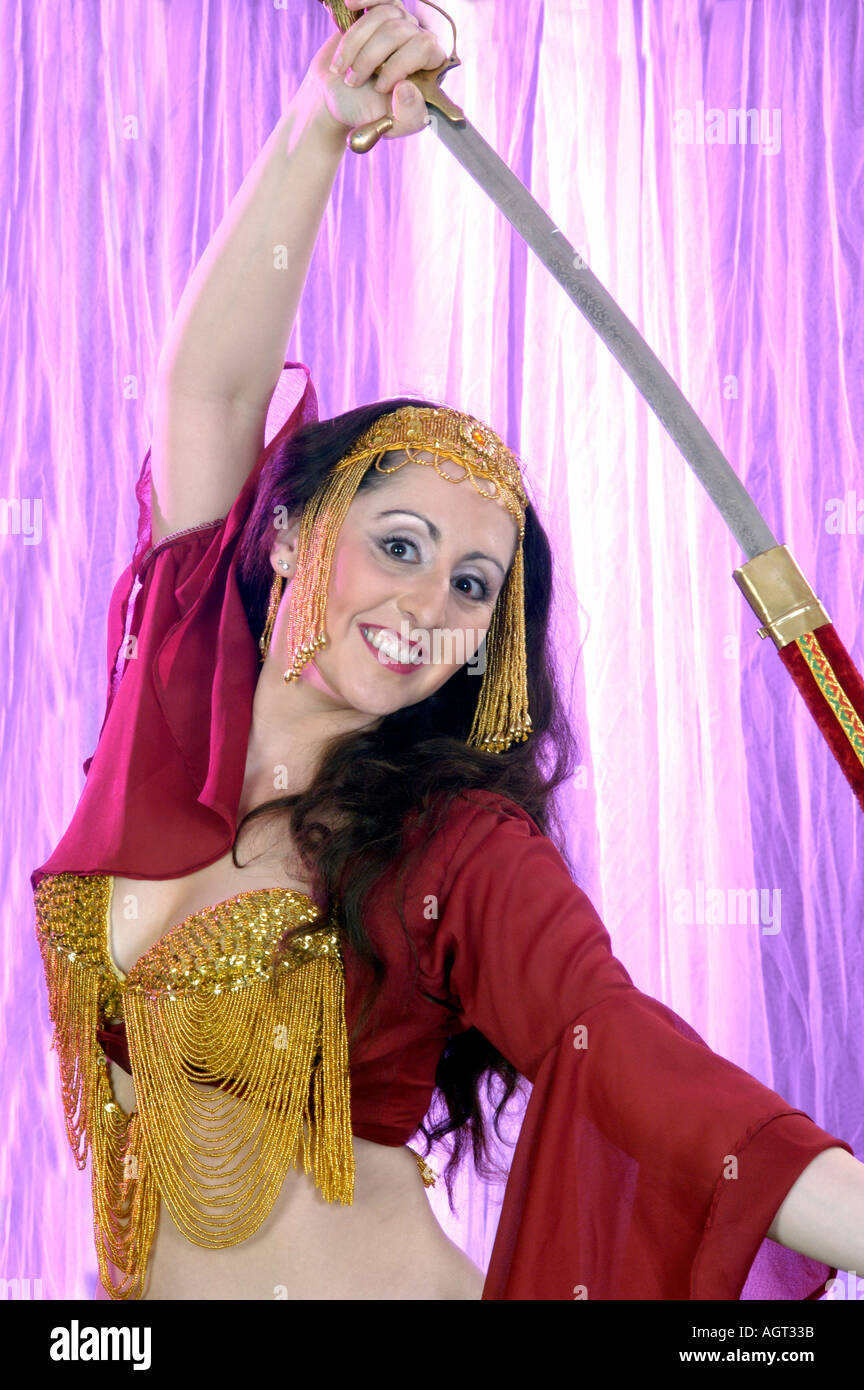 Bella bailarina de danza del vientre en traje rojo con la espada sobre su  cabeza, aislado Fotografía de stock - Alamy