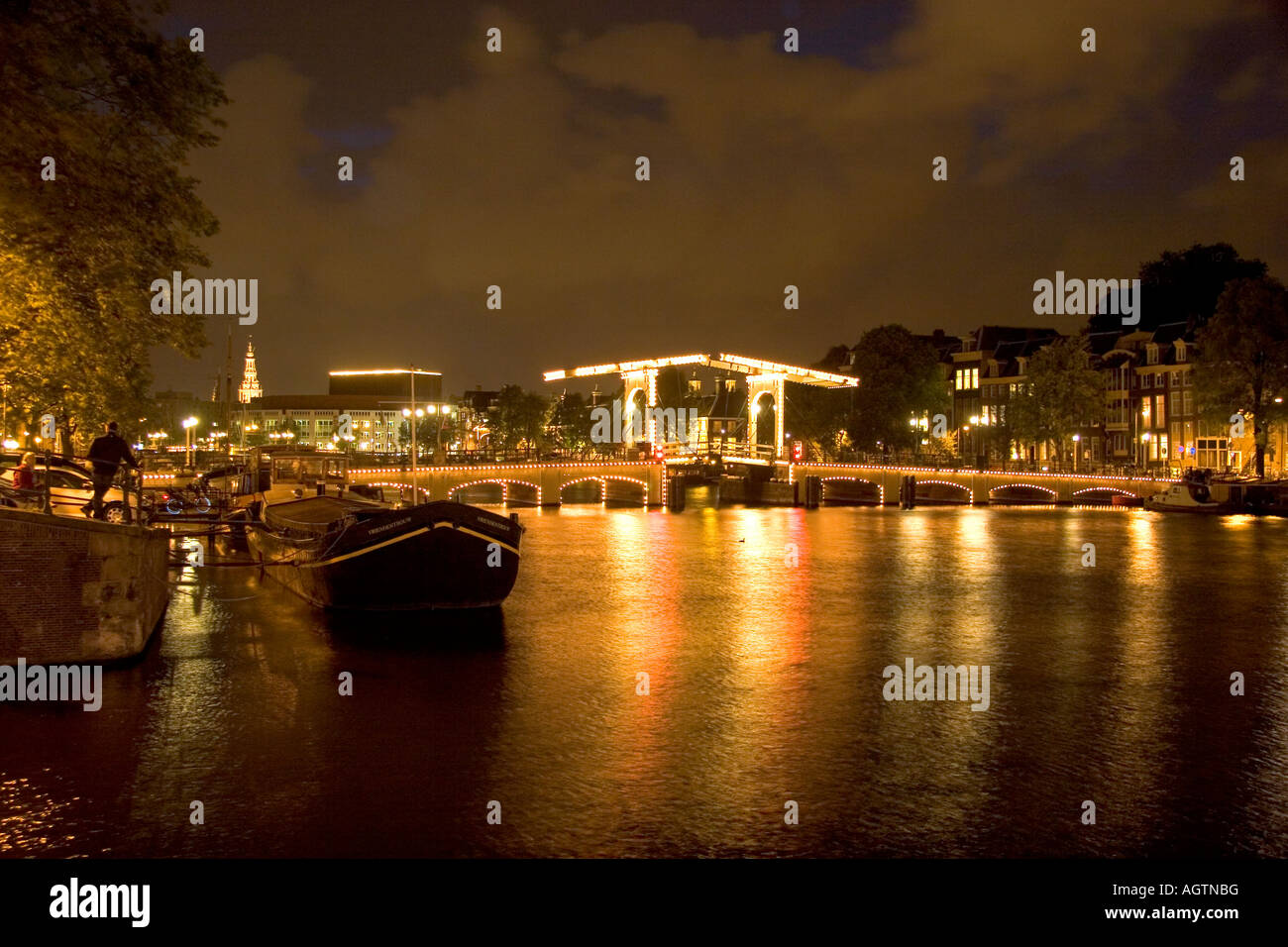 Un puente levadizo iluminados durante la noche, a orillas del río Amstel en Amsterdam, Países Bajos Foto de stock