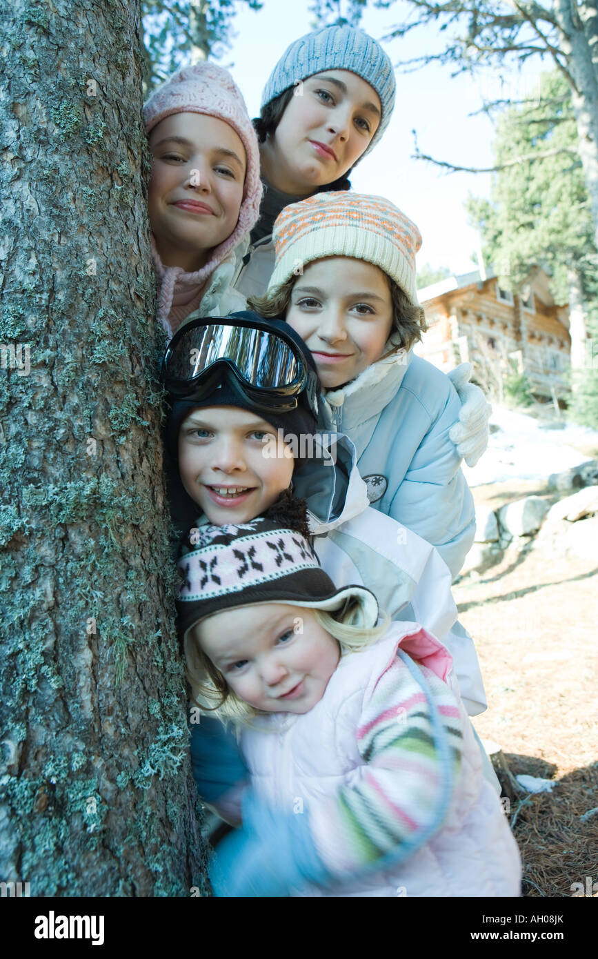 Grupo de adolescentes y niños vestidos con ropa de invierno, posando junto  al árbol, Retrato Fotografía de stock - Alamy
