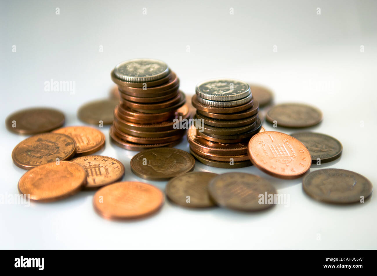 Monedas británicas se apilan en montones con otras monedas tirado junto a ellos Foto de stock