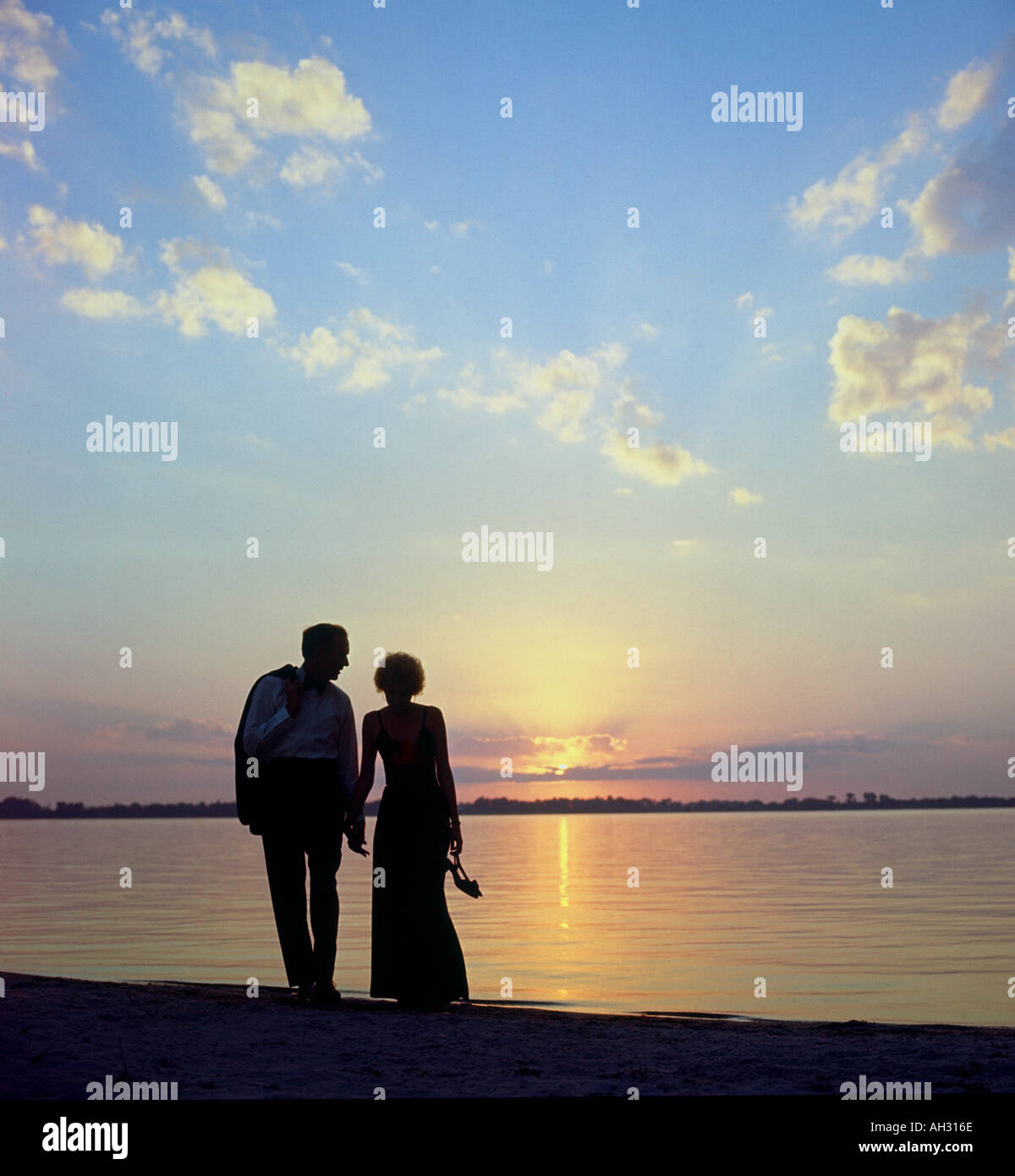 Par caminando por la playa al atardecer en ropa formal Fotografía de stock  - Alamy