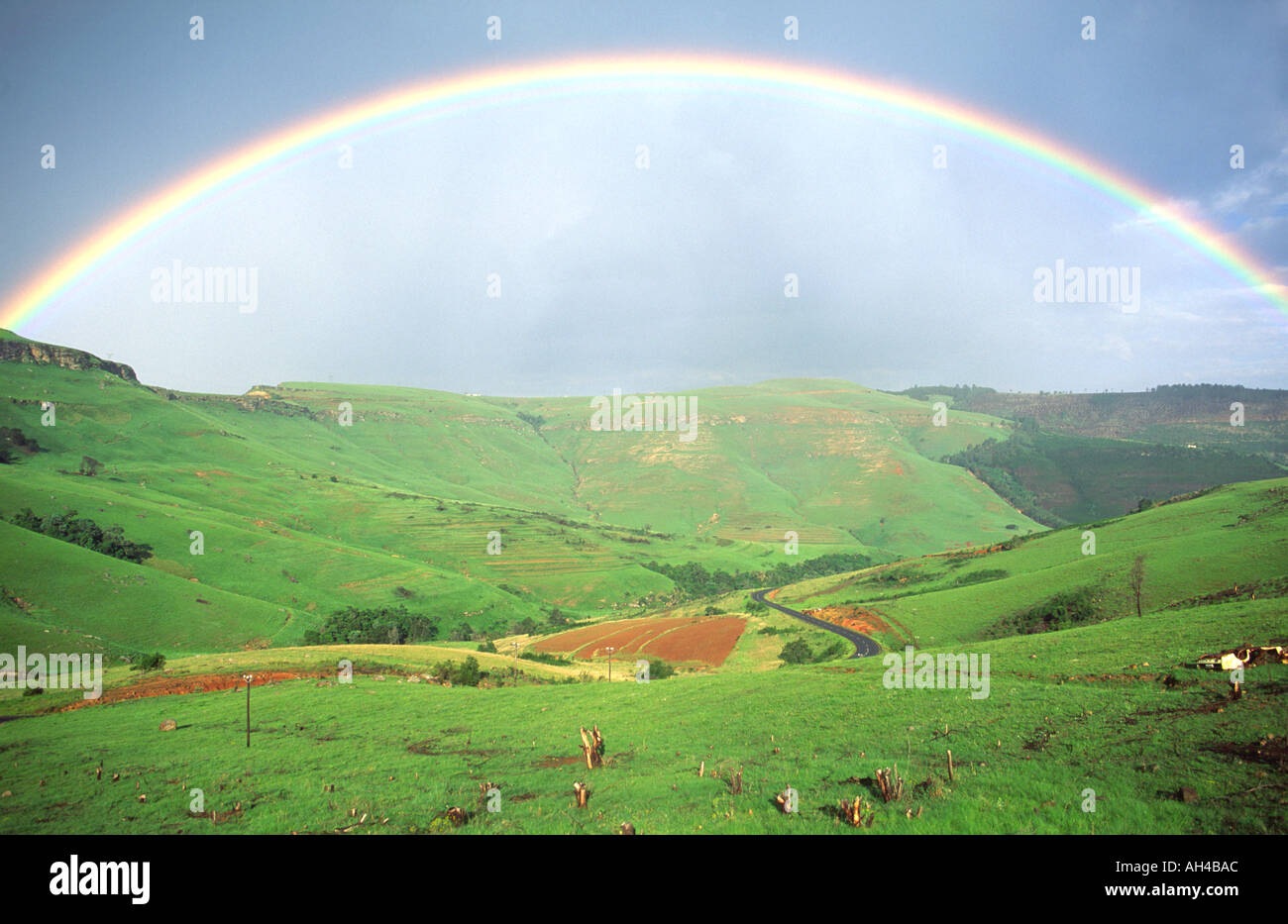 Un arco iris sobre las colinas de la provincia de Eastern Cape en Sudáfrica. Foto de stock