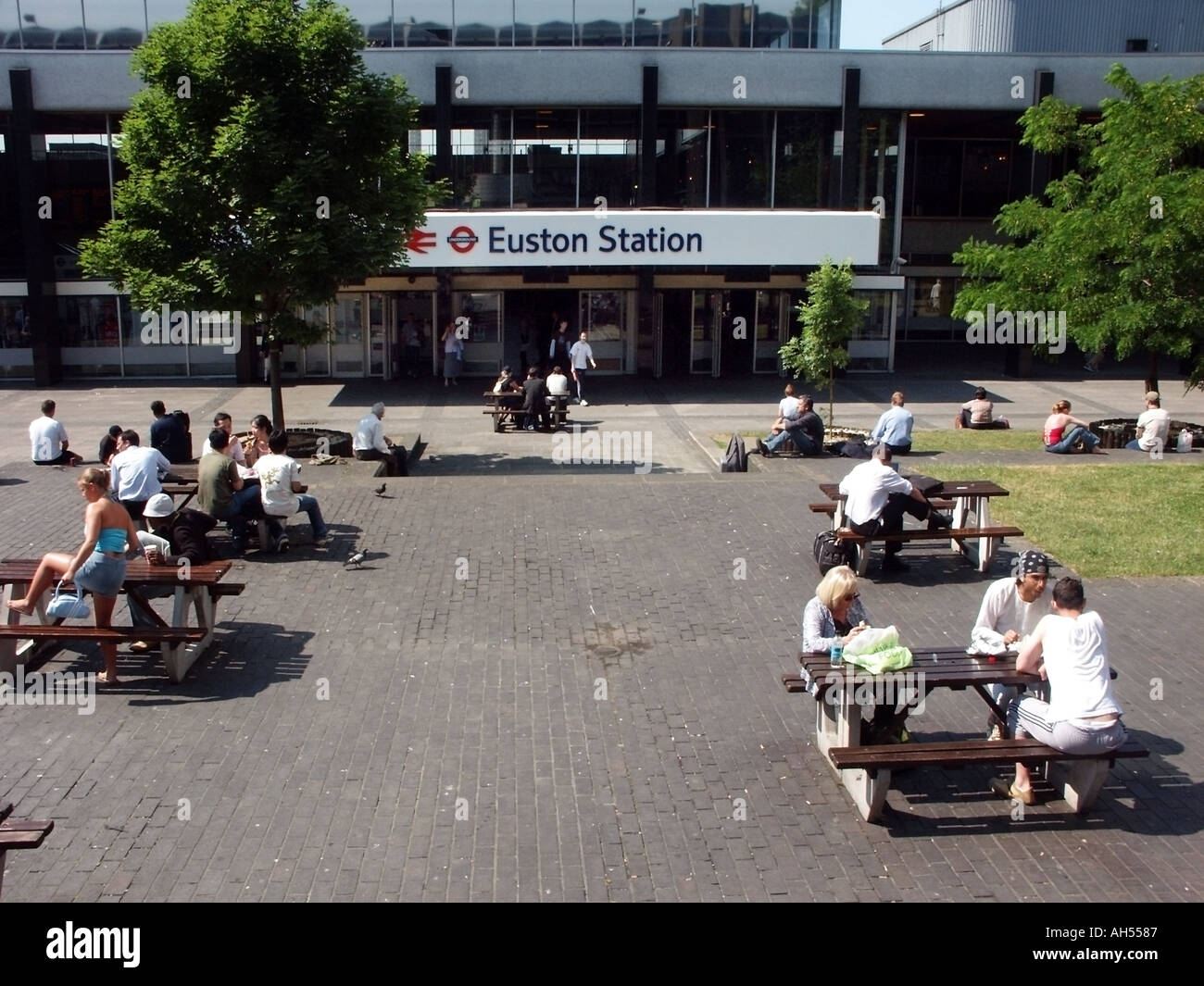 London Euston Station explanada con gente en mesas de picnic al aire libre Foto de stock