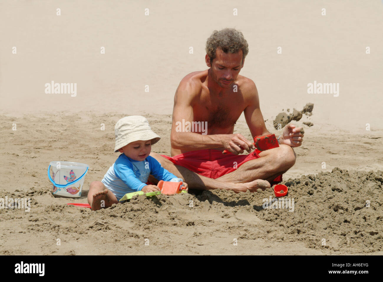 Padre e hijo jugando juntos en la playa en el verano Foto de stock
