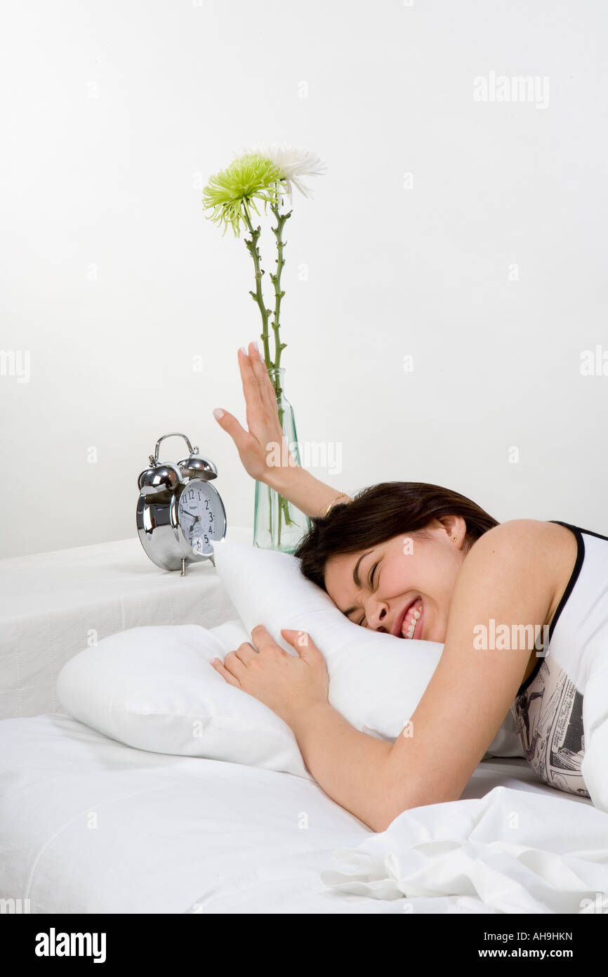 Joven mujer blanca turnning apagada la alarma del reloj Foto de stock