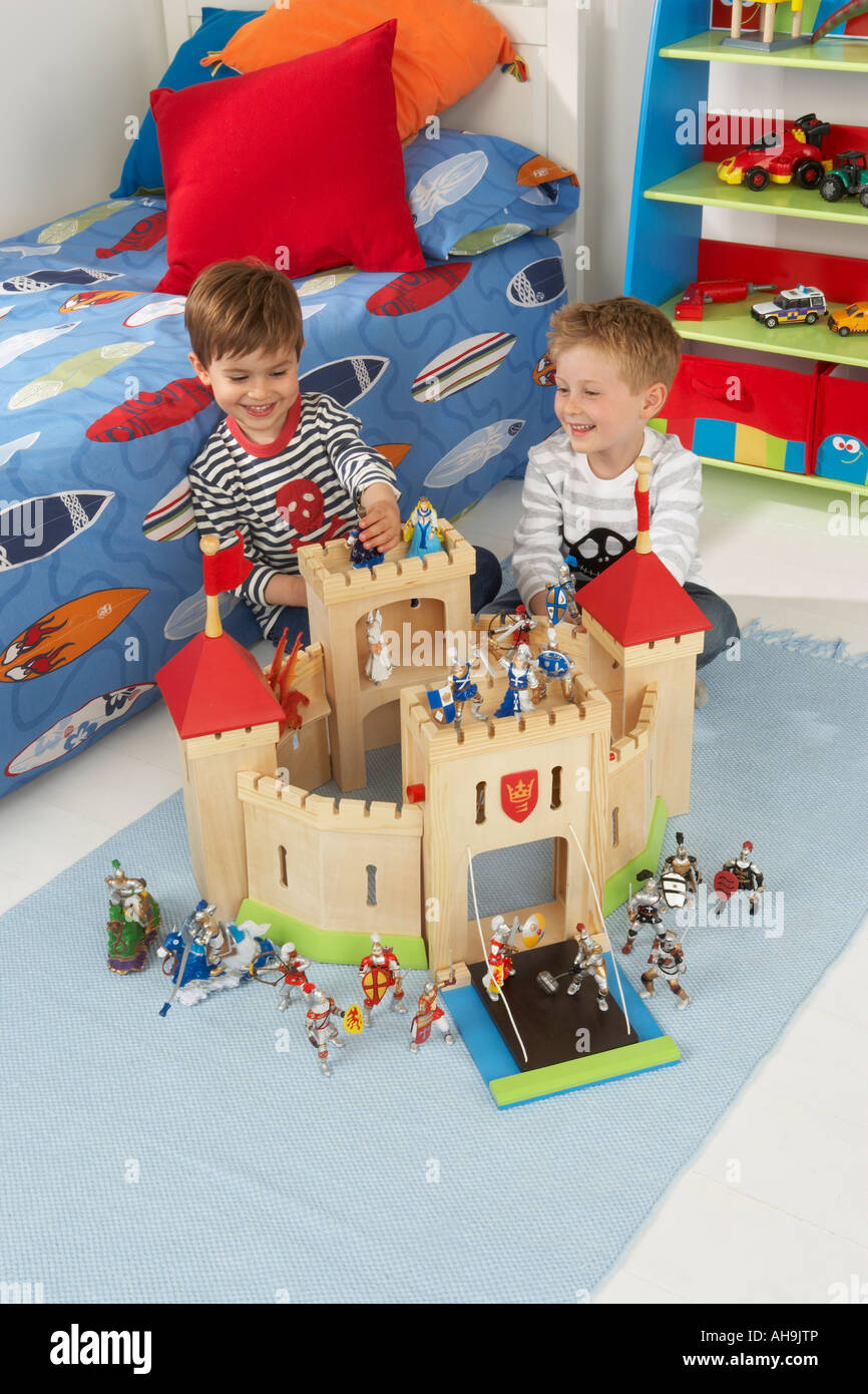 Dos ni os jugando junto con un castillo de juguete en un